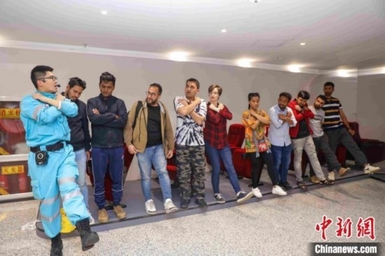 5月9日，工作人員指導(dǎo)留學(xué)生練習(xí)逃生技巧。張鷹 攝