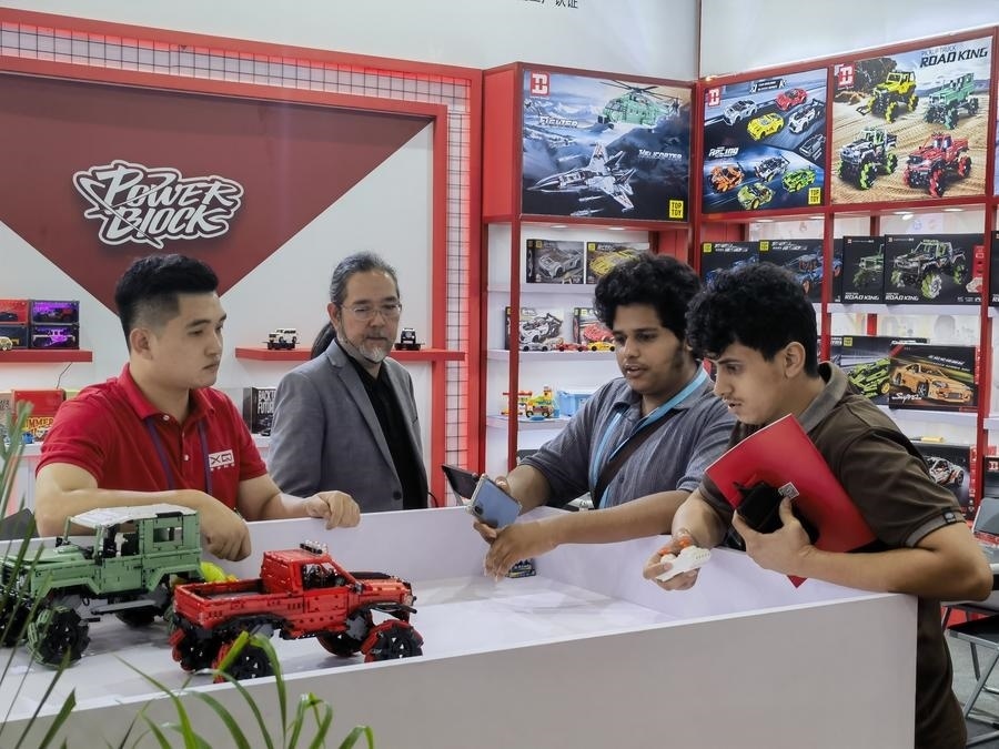 在第135屆廣交會(huì)第三期現(xiàn)場(chǎng)，采購(gòu)商在廣東信宇科技股份有限公司展位選購(gòu)、體驗(yàn)積木遙控車產(chǎn)品（5月2日攝）。新華社記者 洪澤華 攝