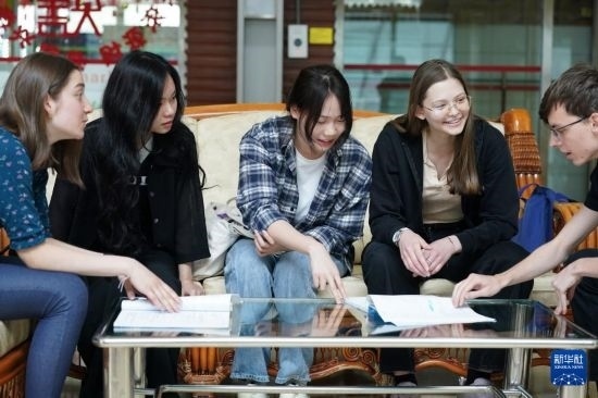 4月28日，宋智孝（右二）和胡靈月（左一）在北京首都師范大學校園內(nèi)與同學交流。新華社記者 彭子洋 攝