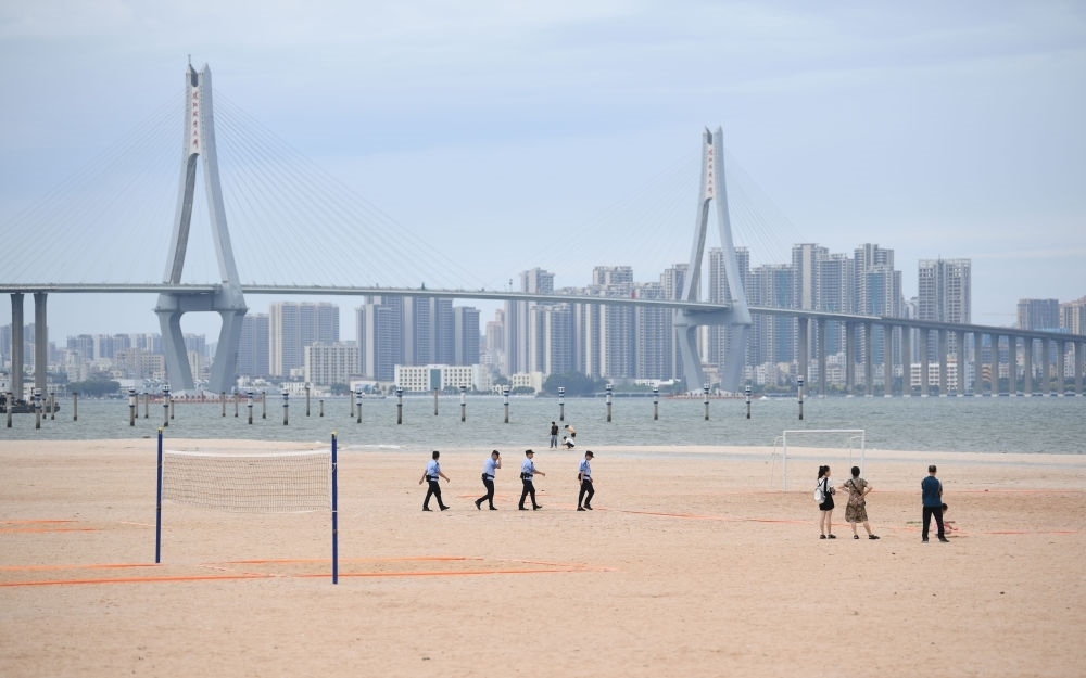 2023年7月17日，廣東湛江五環(huán)廣場的沙灘上，公安民警在執(zhí)勤巡邏。新華社記者 鄧華 攝