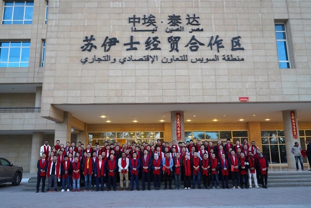 2024年2月11日，在位于埃及蘇伊士省的中?！ぬ┻_蘇伊士經(jīng)貿(mào)合作區(qū)，中埃員工在合作區(qū)辦公大樓前合影拜年。新華社發(fā)（泰達合作區(qū)供圖）