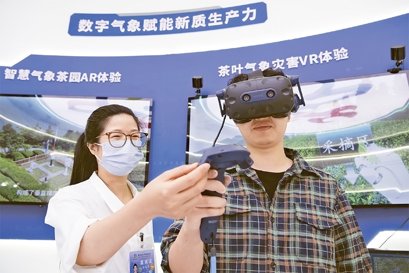 2024年5月23日，第七屆數(shù)字中國建設(shè)峰會現(xiàn)場體驗區(qū)在福州海峽國際會展中心向?qū)I(yè)觀眾開放。本次現(xiàn)場體驗區(qū)圍繞本屆峰會主題“釋放數(shù)據(jù)要素價值，發(fā)展新質(zhì)生產(chǎn)力”，設(shè)置“數(shù)字惠民”、“數(shù)字能力”、“數(shù)字基礎(chǔ)”、“數(shù)字生態(tài)”、“數(shù)字賦能”五大板塊。圖為一名觀眾（右）在數(shù)字氣象賦能新質(zhì)生產(chǎn)力展臺上進行體驗。 新華社記者 魏培全/攝