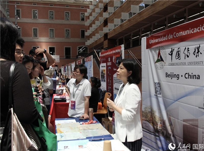 旅西華人華僑在展臺前咨詢。人民網(wǎng)記者 許海林?jǐn)z