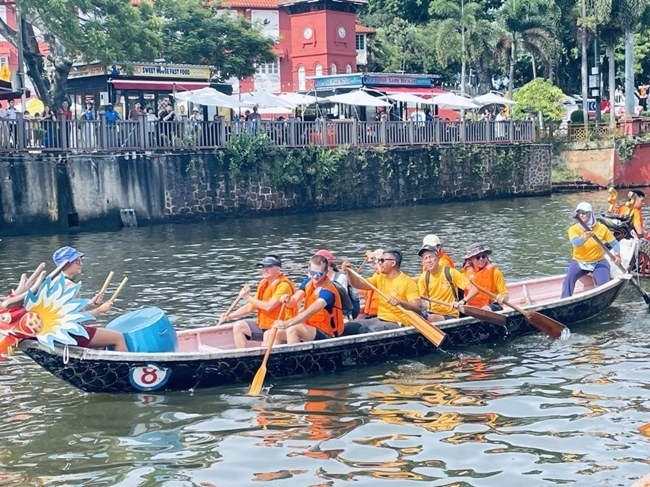 多元種族共同奮輯前進，體驗在馬六甲河劃龍舟，引來大批游客駐足圍觀。組委會供圖