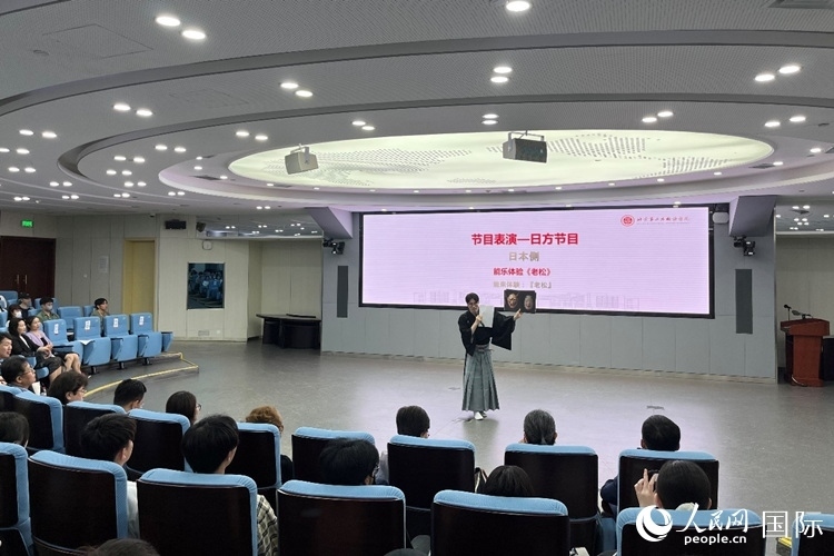 日本大學(xué)生介紹能樂知識。人民網(wǎng)記者 陳思攝