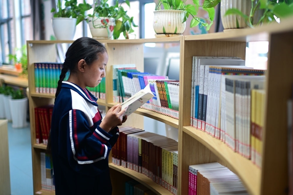 6月18日，果洛西寧民族中學(xué)學(xué)生尼東拉毛在圖書室看書。