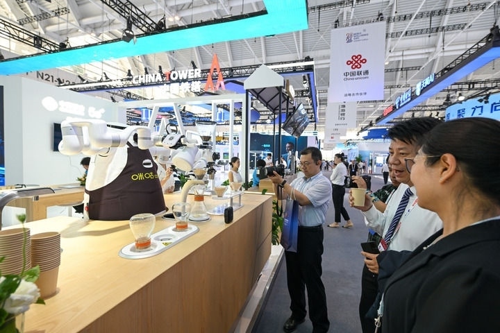 6月20日，與會者品嘗機(jī)器人沖調(diào)出的咖啡。新華社記者 孫凡越 攝