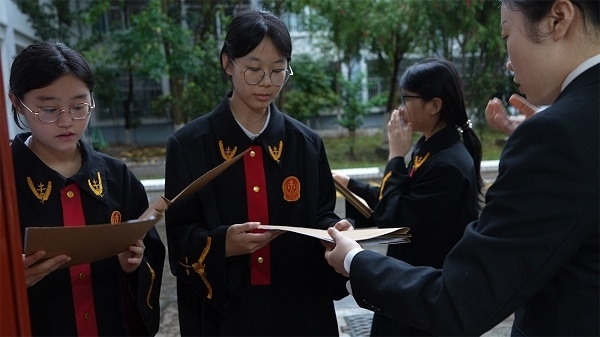 圖①：武平法院干警向?qū)W生分發(fā)道具卷宗。