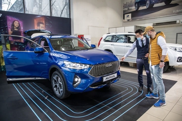 2021年4月1日，銷售人員在哈薩克斯坦阿拉木圖市經(jīng)銷商店向消費(fèi)者介紹哈弗汽車。新華社發(fā)（阿斯塔納汽車公司供圖）