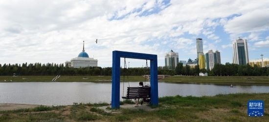 6月30日，一名女子在哈薩克斯坦首都阿斯塔納伊希姆河畔休息。新華社記者 王建華 攝