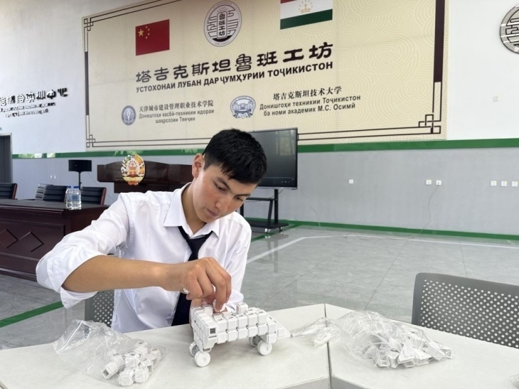 在塔吉克斯坦魯班工坊內(nèi)，學(xué)員正在操作能力源創(chuàng)新套件。本報(bào)記者 屈佩 攝