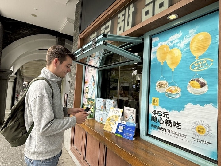 來自德國的留學生理查德在杭州西湖邊一家商鋪使用支付寶掃碼支付（2024年4月11日攝）。新華社發(fā)