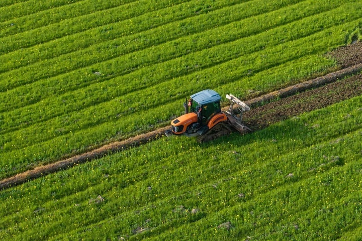 2024年3月19日，在湖南省常德市鼎城區(qū)謝家鋪鎮(zhèn)港中坪村，村民駕駛農(nóng)機(jī)翻耕田地（無人機(jī)照片）。新華社記者 陳思汗 攝