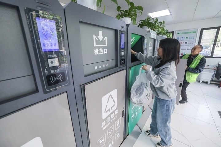 2024年4月10日，在浙江省湖州市吳興區(qū)飛英街道新華府小區(qū)內(nèi)，居民在垃圾分類智能系統(tǒng)的指導(dǎo)下進(jìn)行垃圾分類投放，居民的投放情況將實(shí)時(shí)匯總到智慧服務(wù)平臺，會有相應(yīng)的積分獎勵。新華社記者 徐昱 攝