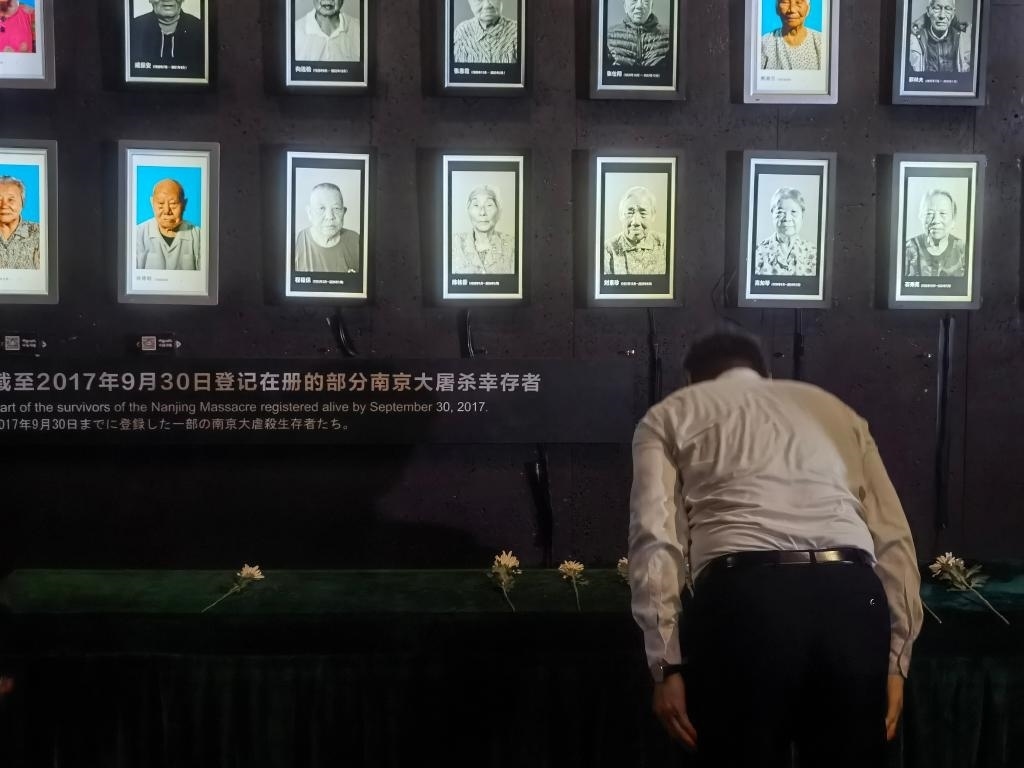 7月18日，人們向離世的南京大屠殺幸存者獻(xiàn)花、鞠躬。新華社記者邱冰清 攝