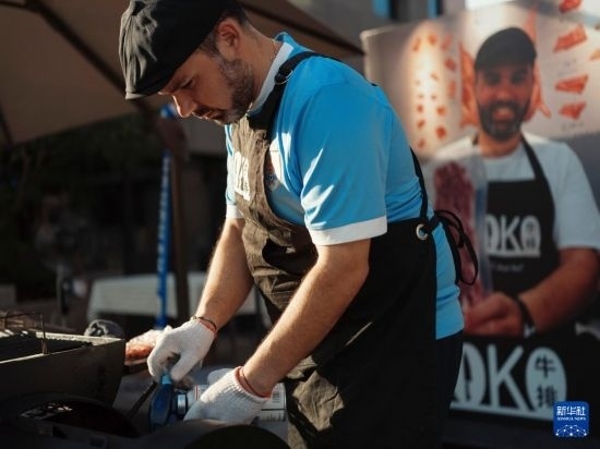 7月19日，在蕪湖古城，馬丁在當(dāng)天舉行的啤酒節(jié)上制作牛排。新華社發(fā)（繆雨晨 攝）