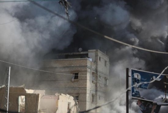 7月21日，在加沙地帶中部的努賽賴特難民營(yíng)，遭以軍空襲的建筑冒出滾滾濃煙。新華社發(fā)（馬爾萬(wàn)·達(dá)烏德攝）