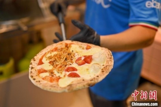 近日，韋榮耀展示他制作的“老友味”披薩。 俞靖 攝