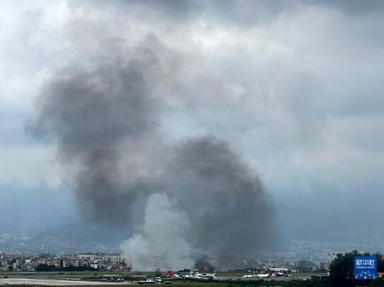 這是7月24日在尼泊爾加德滿都特里布萬機(jī)場拍攝的濃煙。目擊者說，一架飛機(jī)在尼泊爾加德滿都特里布萬機(jī)場墜毀。新華社/美聯(lián)