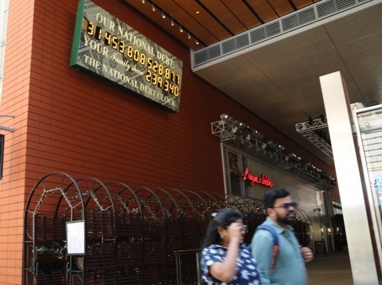 2023年5月29日，人們經(jīng)過(guò)美國(guó)紐約曼哈頓的“國(guó)債鐘”。“國(guó)債鐘”是一個(gè)大型計(jì)數(shù)器，它實(shí)時(shí)更新美國(guó)的公共債務(wù)總額，并顯示出每個(gè)美國(guó)家庭所要負(fù)擔(dān)的數(shù)額。 新華社記者劉亞南攝