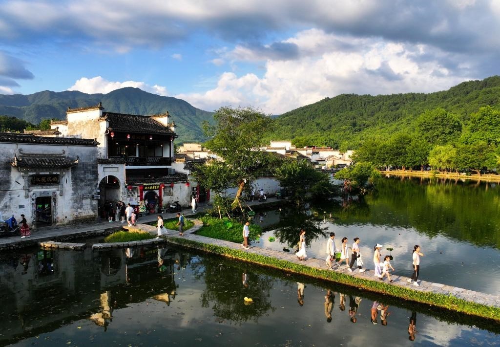 2024年7月7日，游客在安徽省黃山市黟縣宏村游玩。新華社記者杜宇攝