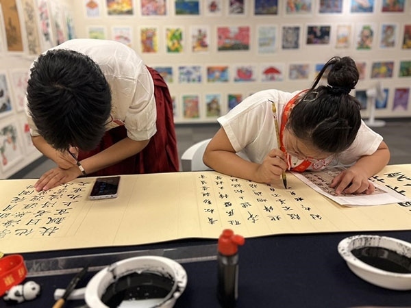 參加本次展覽的青少年在現(xiàn)場進行書法創(chuàng)作。主辦方供圖