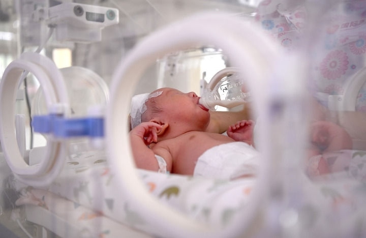 2024年6月1日，在西安國(guó)際醫(yī)學(xué)中心醫(yī)院新生兒科病房，護(hù)士為新生兒喂奶。 新華社記者 劉瀟 攝