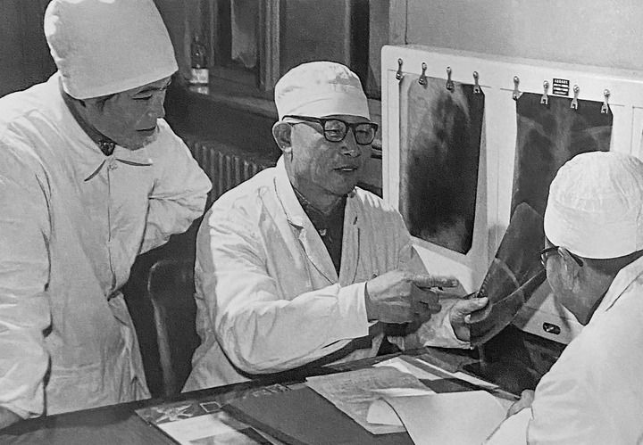 1980年1月16日，中日友好醫(yī)院首任院長(zhǎng)辛育齡（中）在內(nèi)蒙古結(jié)核病院與胸外科醫(yī)師討論病例（翻拍照片）。 新華社發(fā)
