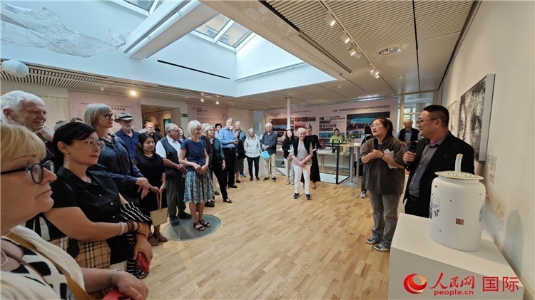 參展人、景德鎮(zhèn)陶瓷大學(xué)美術(shù)學(xué)院副院長邵長宗（右一）向來賓介紹參展作品。人民網(wǎng)記者 殷淼攝