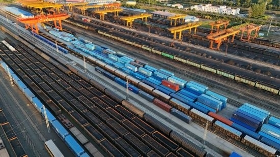 這是2024年8月14日在黑龍江綏芬河鐵路口岸集裝箱換裝場拍攝的集裝箱換裝作業(yè)現(xiàn)場（無人機(jī)照片）。今年前七個(gè)月，綏芬河鐵路口岸開行中歐班列573列，運(yùn)量達(dá)55246標(biāo)箱，同比分別增長23%和18%，班列數(shù)量持續(xù)保持高位運(yùn)行。