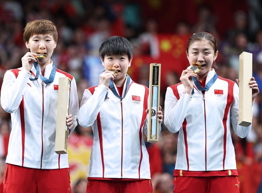 冠軍中國隊選手王曼昱、孫穎莎、陳夢（從左至右）在巴黎奧運會乒乓球女子團體頒獎儀式上（2024年8月10日攝）。新華社記者 王東震 攝