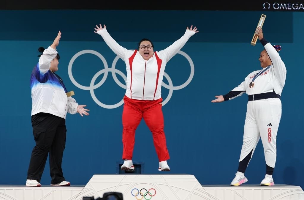中國選手李雯雯（中）在巴黎奧運會舉重女子81公斤以上級頒獎儀式中登上領(lǐng)獎臺（2024年8月11日攝）。新華社記者 楊磊 攝