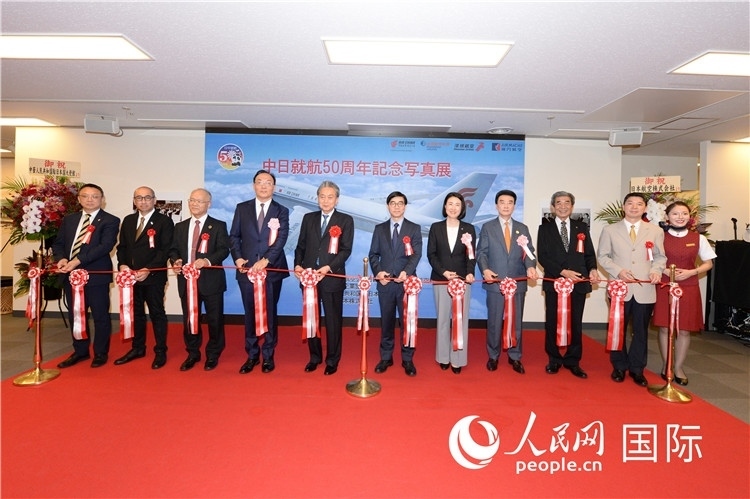 與會(huì)嘉賓共同為中日通航50周年紀(jì)念圖片展開(kāi)幕剪彩。馮學(xué)敏攝