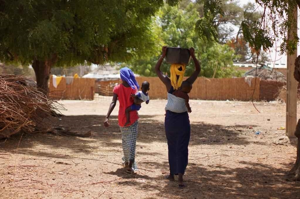 2023年3月20日，在塞內(nèi)加爾久爾貝勒區(qū)的泰內(nèi)富勒村，村民將取到的水運(yùn)回家。新華社記者 王子正 攝