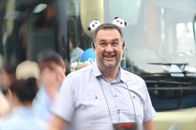 參訪熊貓谷前，塞爾維亞“一帶一路”研究所所長(zhǎng)博揚(yáng)·拉利奇戴上熊貓頭飾。（李佩藺 攝）