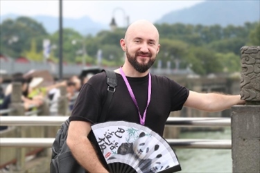 俄羅斯塔斯社執(zhí)行編輯葉夫根尼·扎多羅日內(nèi)在都江堰魚嘴拍照留念。（李佩藺 攝）