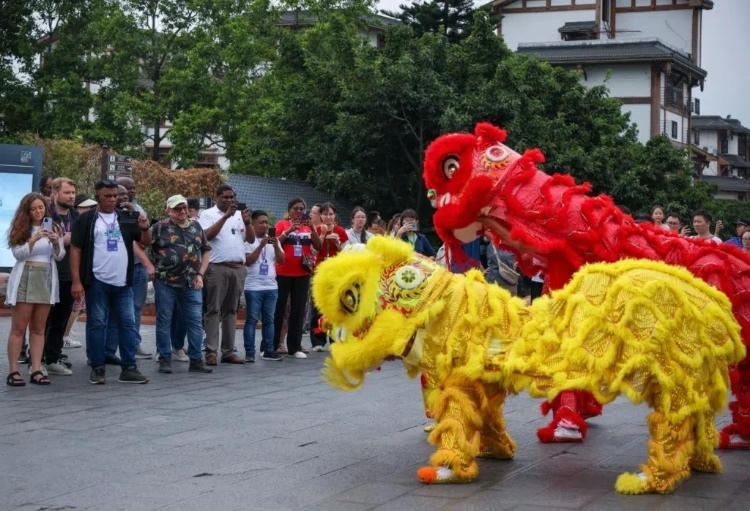 2024“一帶一路”媒體合作論壇聯(lián)合采訪調(diào)研行成員在樂山蘇稽古鎮(zhèn)觀看非遺舞獅表演。本報記者 伊霄攝