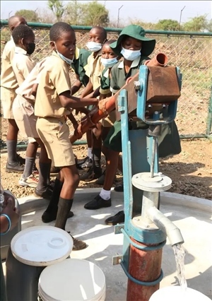 △2021年11月，在津巴布韋南馬塔貝萊蘭省省會關達的塞農(nóng)多小學，學生從中國援建水井里打水。