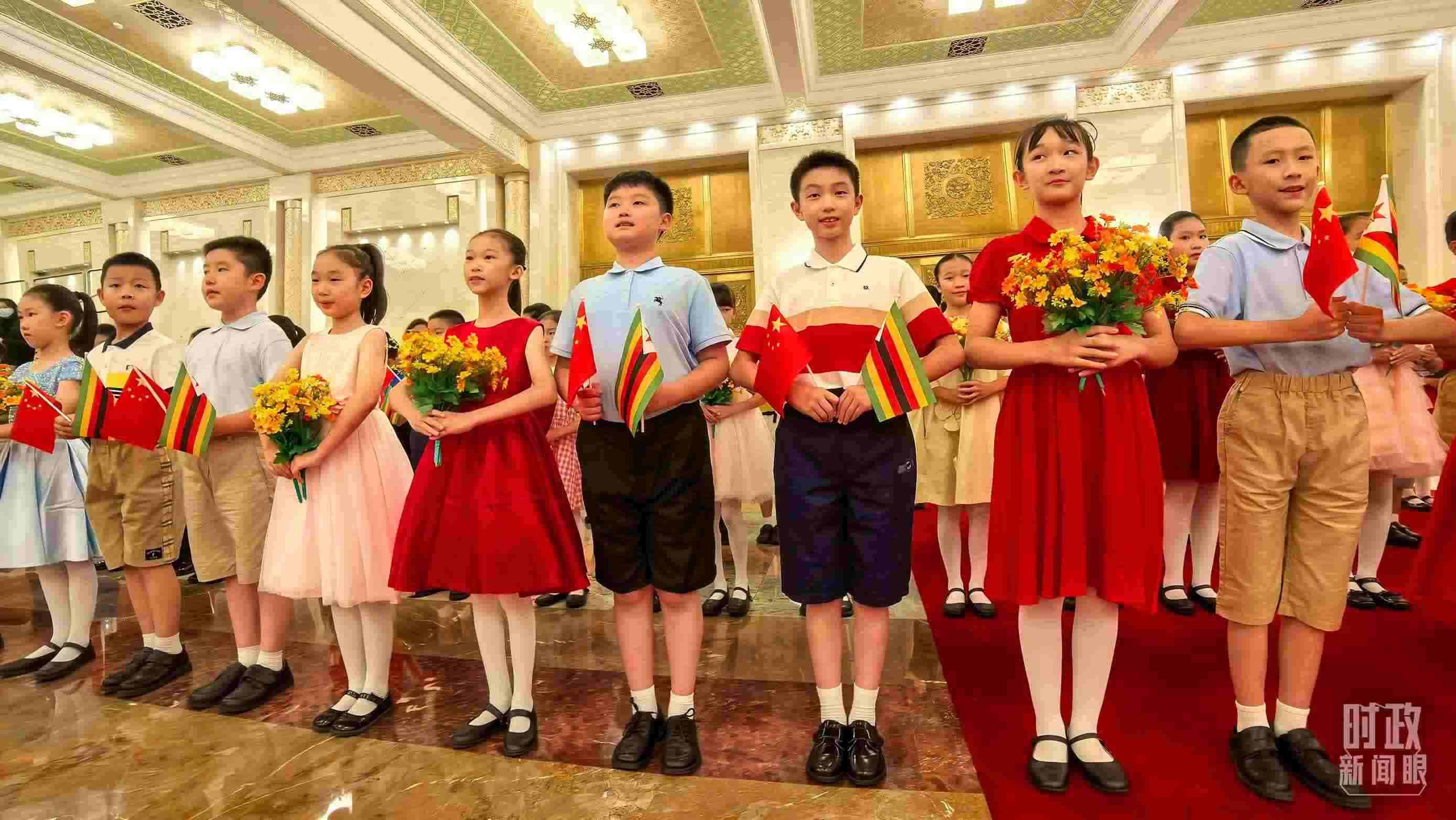 △現(xiàn)場歡迎津巴布韋總統(tǒng)訪華的青少年。（總臺央視記者鐘銳拍攝）