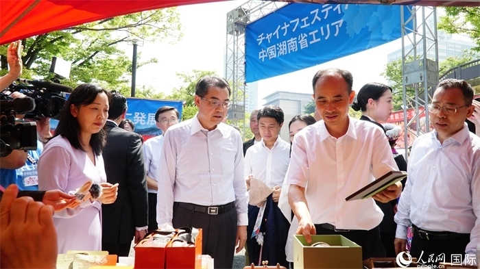 湖南展位工作人員向中國駐日本大使吳江浩介紹特色文創(chuàng)產(chǎn)品。人民網(wǎng) 蔣曉辰攝