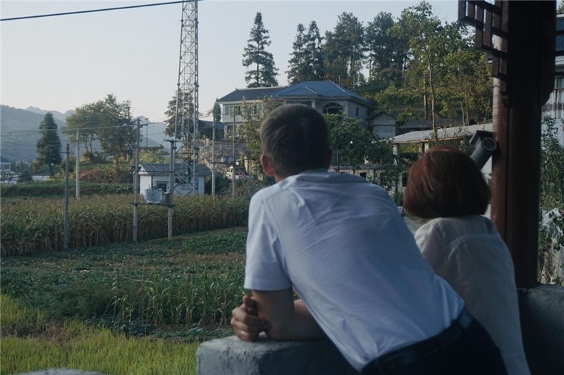 望得見山，看得見水，記得住鄉(xiāng)愁。每個人心中都有一個屬于自己的“花茂村”，在這方心田，走遍千山萬水，鄉(xiāng)音未改鬢毛衰。吉爾吉斯斯坦《比什凱克晚報》第一副總編輯妮娜·尼奇博洛娃與《中國與俄羅斯》雜志社社長奧列格·別列日內(nèi)赫攝在花茂村民居屋檐下并肩佇立，眺望山水，尋覓鄉(xiāng)愁。（李光裕攝）