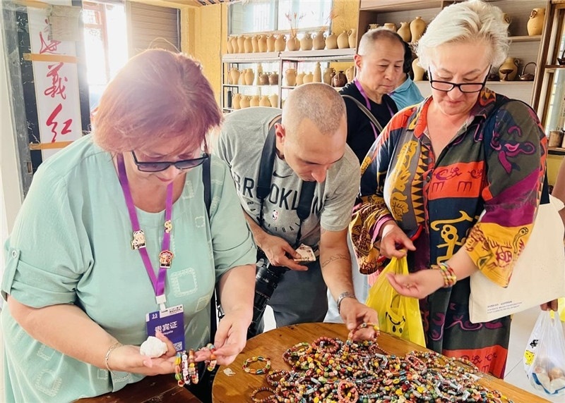 歐亞媒體考察團成員在母氏陶藝館內(nèi)挑花了眼，色彩絢麗、質(zhì)地均勻的陶藝手串讓他們愛不釋手。“這里的東西都太實惠了！”塔吉克斯坦《索格特真理報》政論部主任娜塔利婭·多羅費耶娃說。花茂村的特色產(chǎn)品物美價廉，讓考察團成員為家人好友買到了心儀的禮物，也為此次以四川成都為起點，路經(jīng)南充、廣安至貴州遵義的考察行程畫上了圓滿句號。（張亞欣攝）
