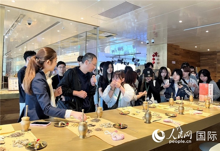 1. 日中友好協(xié)會青年代表團一行學習中醫(yī)香囊制作工序。（人民網(wǎng)記者陳思 攝）