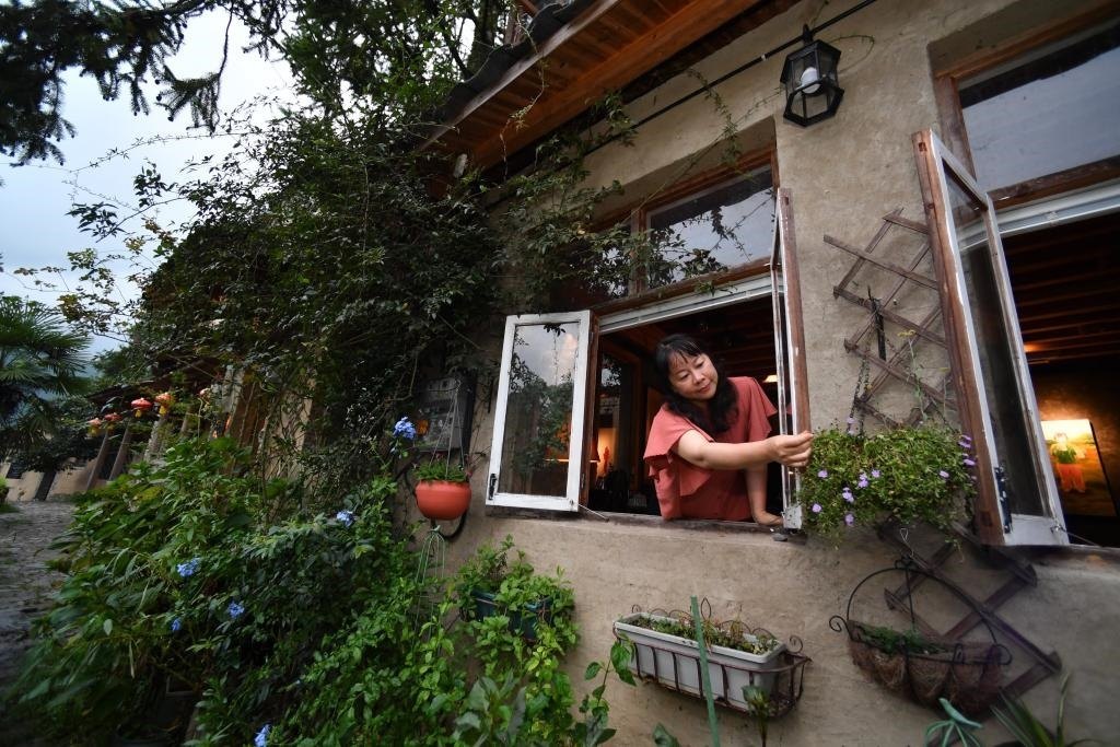 8月29日，在福建省屏南縣熙嶺鄉(xiāng)，龍?zhí)洞濉靶麓迕瘛泵泛暝诖蚶碜约航?jīng)營的民宿外墻裝飾花盆。新華社記者姜克紅 攝