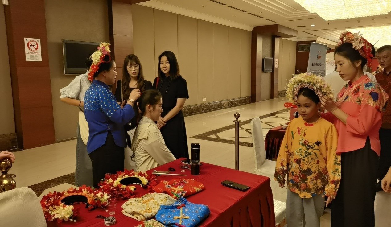 阿拉扎大學孔子學院志愿者老師向傳承人學習簪花圍。阿拉扎大學孔子學院供圖