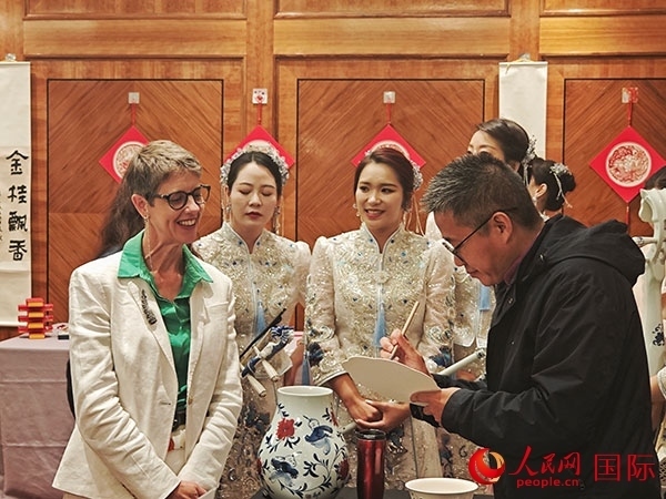 現(xiàn)場(chǎng)的非遺傳承人為英國(guó)觀眾展示畫技。人民網(wǎng)記者 邢雪攝