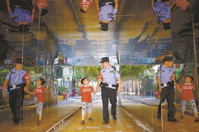 ?7月16日，重慶市公安局江北區(qū)分局一名民警在巡邏途中遇到一個(gè)獨(dú)自玩耍的小男孩，民警將其送回家。王洪平攝