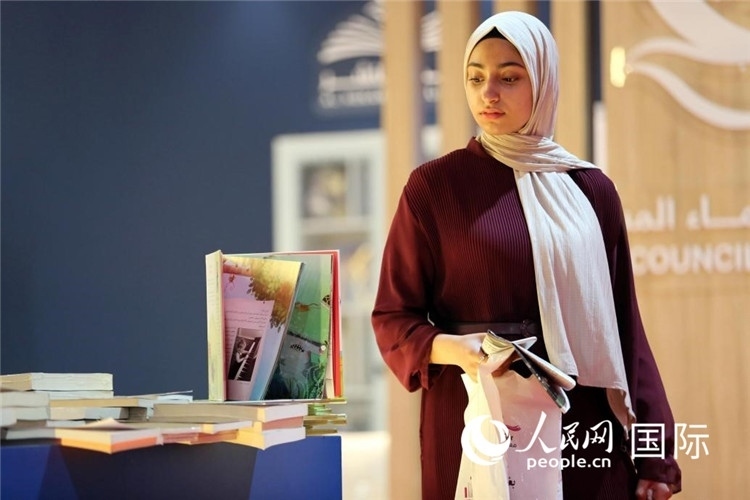 一名女性走過展臺。人民網(wǎng) 奧馬爾·哈利勒攝