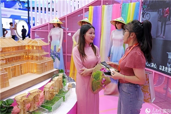 參觀者在東博會(huì)越南展區(qū)同工作人員咨詢交談。人民網(wǎng)記者 趙益普攝