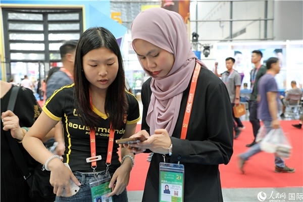 東博會(huì)現(xiàn)場，馬來西亞展商在同中方工作人員交談。人民網(wǎng)記者 趙益普攝